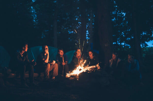 A group of people (circle) around a fire.