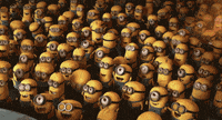Despicable Me gif. A huge crowd of minions cheers enthusiastically, dancing together, jumping up and down, raising their arms, as a spot light pans over them.